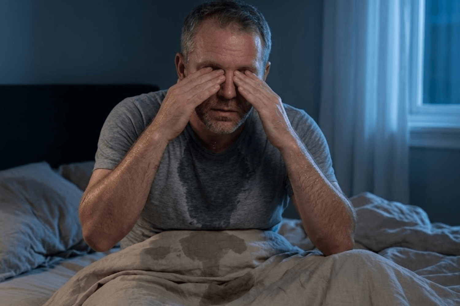 Man struggling with sleep deprivation due to night sweats