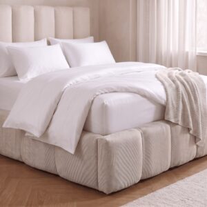 Bed made with ZLEEPY white bamboo bedding, fitted sheet corner showing