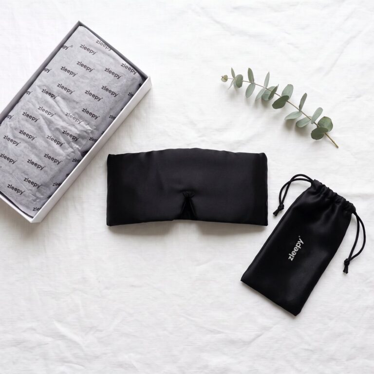 The ZLEEPY Wrap silk sleep mask on a silk pillow